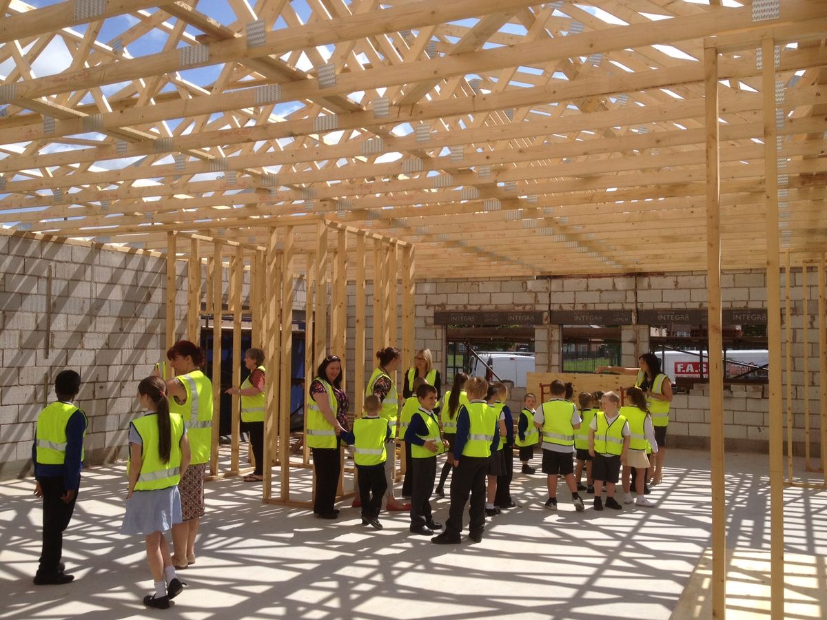 Pupils visiting the timber roof structure during works at Blueberry Park Primary