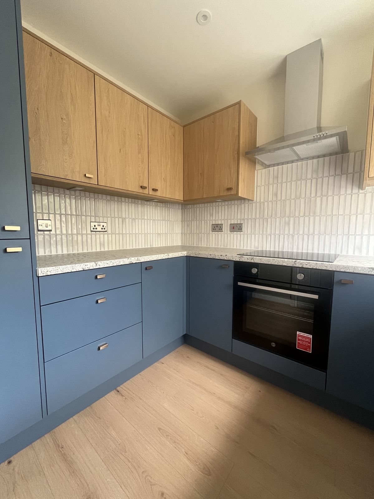 Blue and oak kitchen with kit-kat tile splashback at Sorrel Way